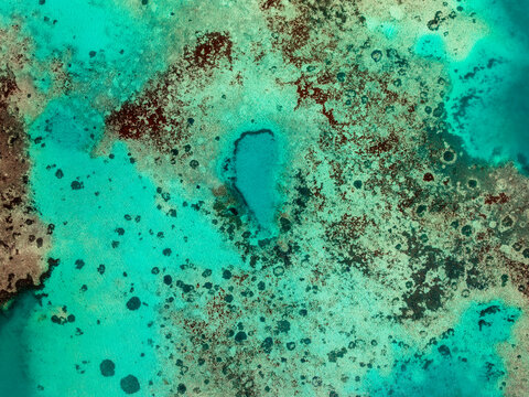 Aerial view of a vibrant coral reef with turquoise lagoon waters and intricate patterns of coral formations in Mauritius.