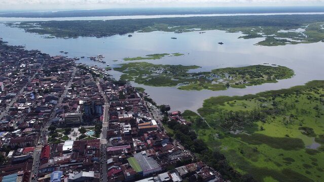 Aerial view of the city of Iquitos featuring dense urban streets, rooftops, and surrounding lush wetlands along the Amazon River in Iquitos, Loreto, Peru.