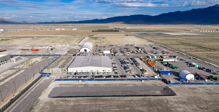 Aerial view of warehouses supporting the data center and new construction with industrial equipment, parking lots, and surrounding desert landscape in Eagle Mountain, Utah, United States.