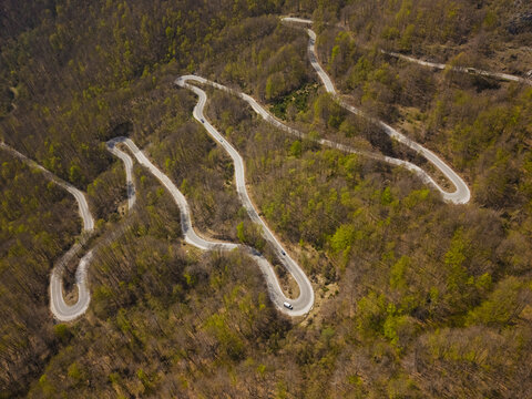 Aerial view of the winding serpentine road through the dense forest of Durmitor National Park in Zabljak, Zabljak Municipality, Montenegro.