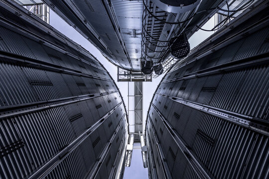 View of industrial metal grain silos with corrugated surfaces and vertical ladders reaching towards the sky in Nairobi, Nairobi County, Kenya.