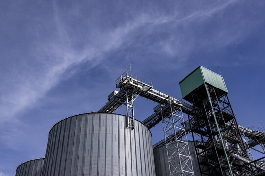 View of industrial grain silos with metal structures and conveyor systems under a blue sky in Nairobi, Nairobi County, Kenya.