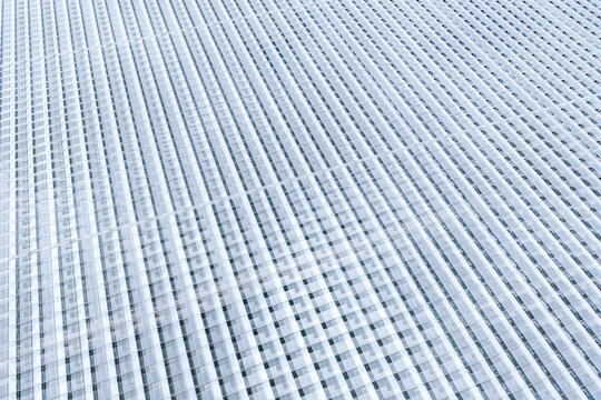 Aerial view of a large greenhouse with a repeating glass grid pattern in Poland.