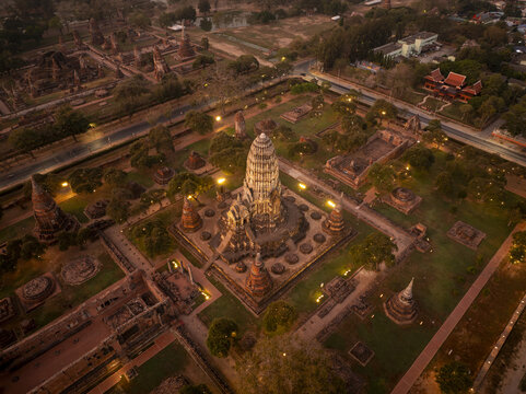 Aerial view of Wat Ratchaburana featuring ancient brick ruins, temple grounds, illuminated paths, and lush greenery in Amphoe Phra Nakhon Si Ayutthaya, Chang Wat Phra Nakhon, Thailand.