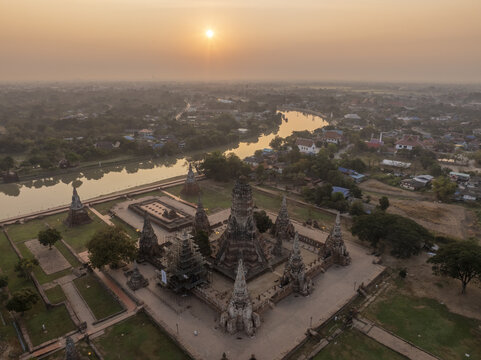 Aerial view of Wat Chaiwatthanaram temple ruins at sunset with the river and lush greenery in Tambon Ban Pom, Chang Wat Phra Nakhon, Thailand.