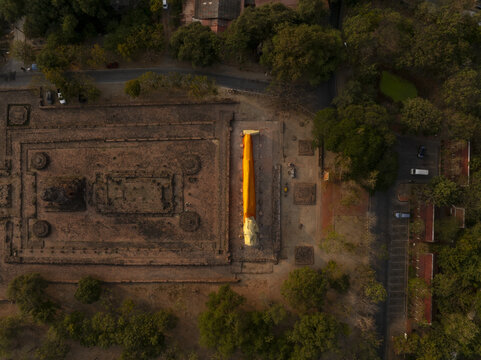 Aerial view of the reclining Buddha statue at Wat Lokaya Sutha surrounded by ancient temple ruins and lush trees in Phra Nakhon Si Ayutthaya District, Phra Nakhon Si Ayutth, Thailand.
