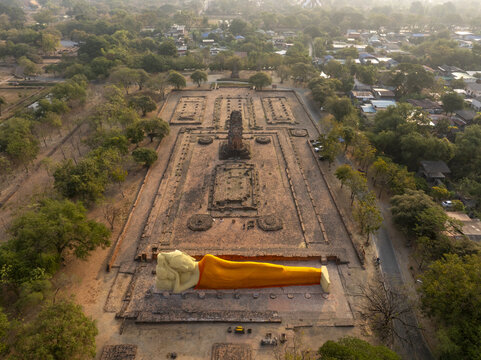 Aerial view of the reclining Buddha statue at Wat Lokaya Sutha surrounded by ancient brick ruins and lush trees in Phra Nakhon Si Ayutthaya District, Phra Nakhon Si Ayutthaya, Thailand.