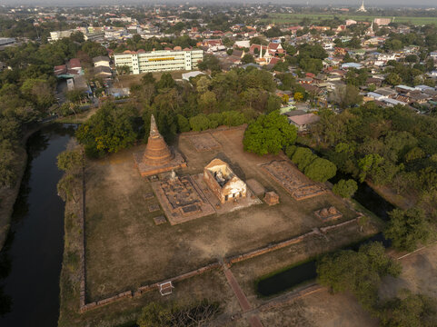 Aerial view of the ruins of Wat Worachettharam with a brick stupa and temple remains surrounded by a moat and trees in Phra Nakhon Si Ayutthaya District, Phra Nakhon Si Ayutth, Thailand.