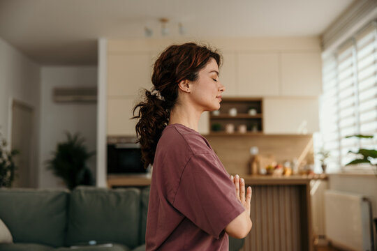 Woman meditating at home practicing mindfulness and yoga
