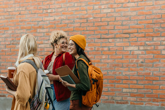 Diverse students walking on campus talking and smiling