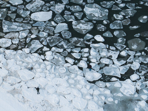 Sopot, Pomeranian Voivodeship, Poland - 20 February 2026: Aerial view of ice floes floating on the cold Baltic Sea with two people standing on the frozen surface.