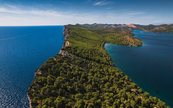 Aerial view of Telascica Nature Park featuring dramatic cliffs, dense pine forests, and the deep blue Adriatic Sea in Sali, Zadar County, Croatia.