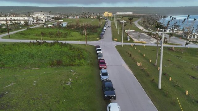San Jose, Tinian, Northern Mariana Islands - 07 July 2026: Aerial view of a long line of vehicles waiting at a gas station following fuel shortages caused by typhoon Bavi.