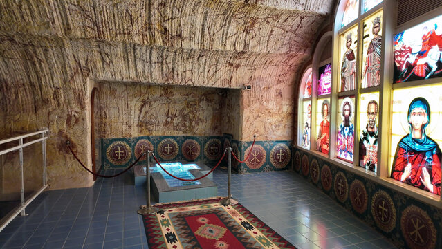 Coober Pedy, South Australia, Australia - 15 January 2025: View of the underground Serbian Orthodox Church with carved rock walls, stained glass windows, and a central baptismal font.