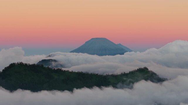 Aerial view of Dieng Plateau with volcanic peaks rising above a thick sea of clouds at sunrise in Kecamatan Batur, Jawa Tengah, Indonesia.