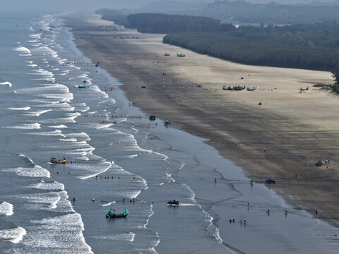 Cox's Bazar, Bangladesh - 10 April 2026: Aerial view of Cox's Bazar Sea Beach with traditional fishing boats along the shoreline, sandy beach, and lush coastal vegetation.