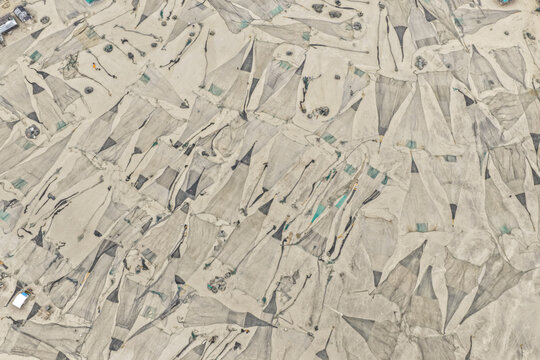 Cox's Bazar, Bangladesh - 09 April 2026: Aerial view of fishing nets spread out to dry on the sandy beach, creating a geometric pattern across the landscape.