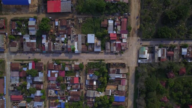 Aerial view of residential neighborhood with colorful rooftops and dirt roads in Pucallpa, Ucayali, Peru.