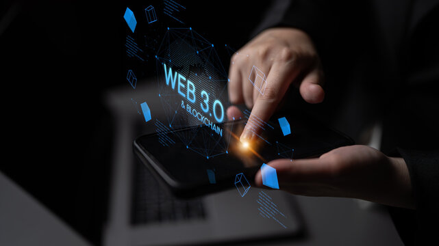 Hands Interacting with Smartphone Displaying Web 3.0 and Blockchain Technology Concept in Dark Environment. Entropy.