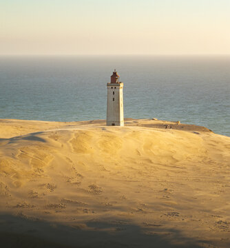 Aerial view of Rubjerg Knude lighthouse standing on the sandy dunes by the sea in Lokken, Denmark.