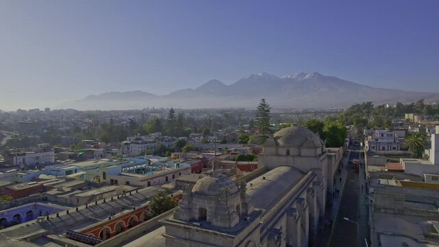 Aerial view of the historic center of Arequipa, featuring colonial church architecture, surrounding urban rooftops, and the prominent Misti volcano in Arequipa, Arequipa, Peru.