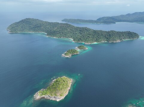 Aerial view of Ko Hin Ngam Noi surrounded by lush tropical vegetation and turquoise waters in the Andaman Sea, Ko Tarutao, Satun, Thailand.