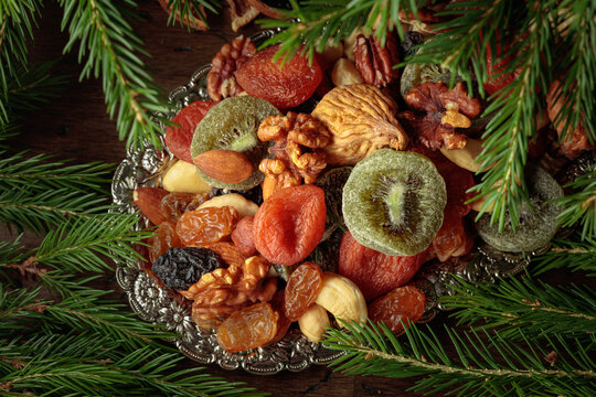 Assorted dried fruits and nuts on a silver tray.