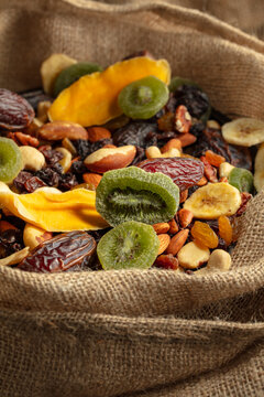 Dried tropical fruits and nuts in burlap bag.