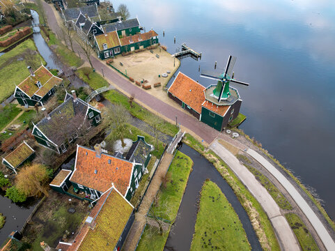 Aerial view of the historic Zaanse Schans windmills and traditional green wooden houses situated along the Zaan river in Zaandam, Noord-Holland, Netherlands.
