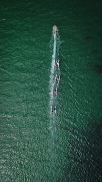 Aerial view of small sailboats participating in sailing lessons on the green sea in Carantec, Brittany, France.