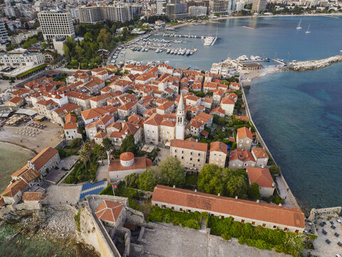 Budva, Montenegro - 18 April 2026: Aerial view of the historic old town with terracotta rooftops, the medieval citadel, and the Adriatic Sea coastline.