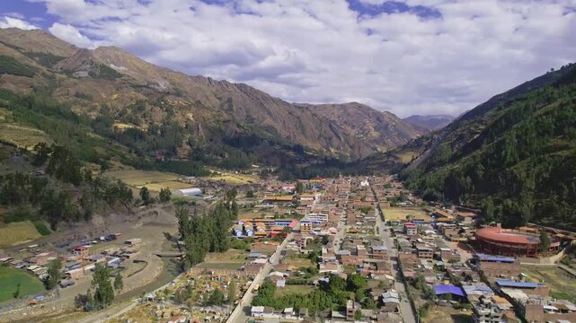 Aerial view of the historic town of Chavin de Huantar nestled in the Andes mountains with surrounding agricultural fields and rugged terrain in Chavin de Huantar, Ancash, Peru.