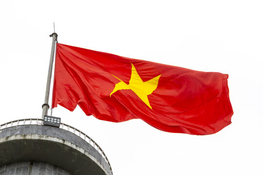 View of the national flag of Vietnam waving on a pole atop a concrete structure along the Ha Giang Loop in Dong Van, Tuyen Quang, Vietnam.