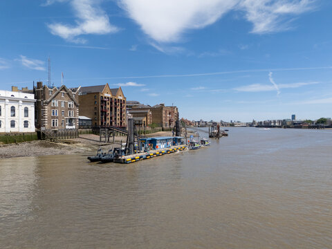 London, United Kingdom - 06 July 2026: Aerial view of the Metropolitan Police Marine Policing Unit on the River Thames, with police boats docked by historic brick buildings under a blue sky.
