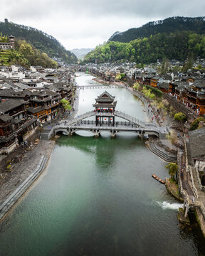 Aerial view of Fenghuang Ancient Town with traditional wooden architecture, stone bridges, and the Tuojiang River in Xiangxi Tujia and Miao Autonomous Prefecture, Hunan, China.