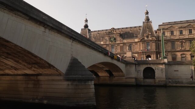 Stone bridge over the Seine in front of a Paris palace facade