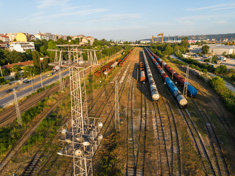 Aerial view of the southern industrial zone in Varna, featuring railway tracks with freight trains, cargo containers, and surrounding urban infrastructure in Varna, Varna, Bulgaria.