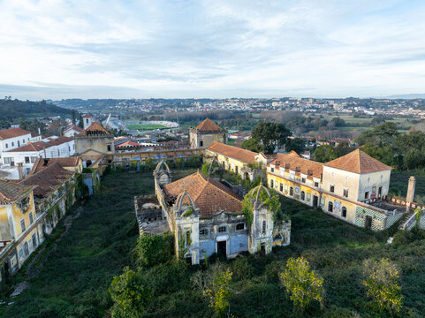 Aerial view of the abandoned Quinta Conde de Sucena with its overgrown courtyard and historic terracotta-roofed buildings in the rural landscape of Borralha, Aveiro, Portugal.