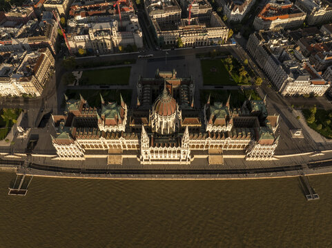 Aerial view of the Hungarian Parliament Building with its iconic dome and Gothic Revival architecture situated along the Danube River in Budapest, Hungary.