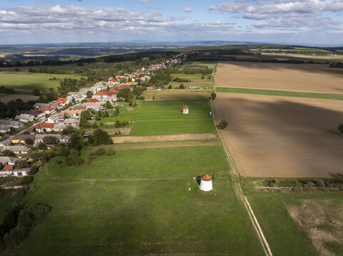 Aerial view of the historic Tesi Windmills and Smithy surrounded by green fields and the village of Tes, Hungary.