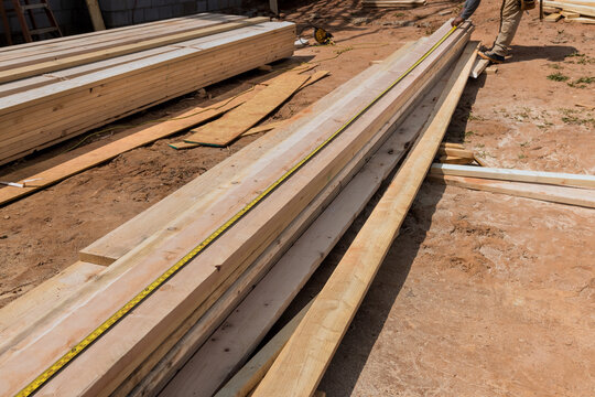 Workers are busy measuring organizing wooden planks on construction site under works area