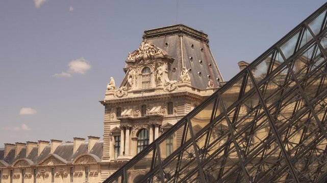 Steel and glass pyramid edge against a Paris palace roof