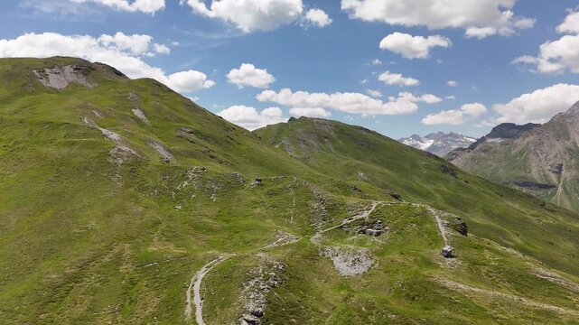 Cinematic aerial drone shot flying over rolling green alpine meadows and mountain ridges in Obernberg am Brenner, Austria.⁠