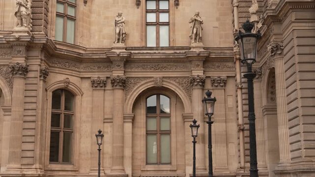 Tall arched windows and lamps on a Paris palace facade