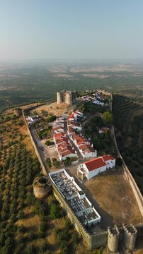 Aerial view of the historic hilltop castle and village of Evoramonte surrounded by olive groves in Portugal.