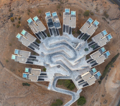 Aerial view of the Beresheet Hotel in the Negev desert, featuring unique architecture with rooftop pools and winding pathways in Mitzpe Ramon, South District, Israel.