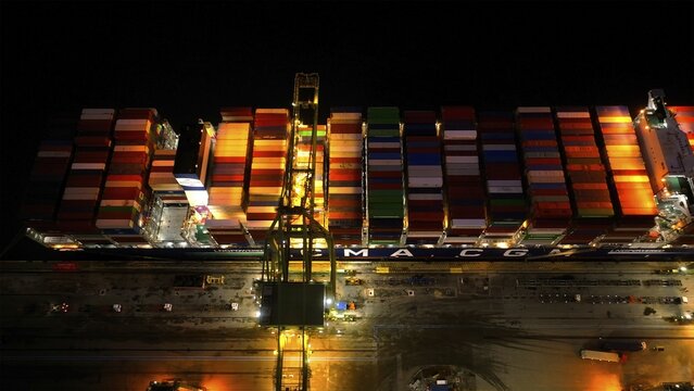 Rio de Janeiro, Rio de Janeiro, Brazil - 17 June 2026: Aerial view of a container ship at Porto do Rio de Janeiro at night, with colorful shipping containers under bright lights.