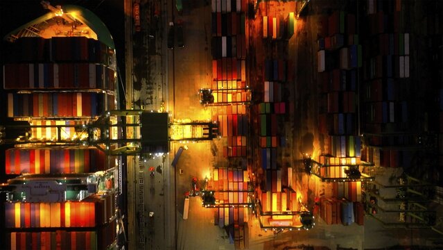 Rio de Janeiro, Brazil - 17 June 2026: Aerial view of Porto do Rio de Janeiro at night, featuring rows of colorful shipping containers and industrial cranes illuminated by bright lights.