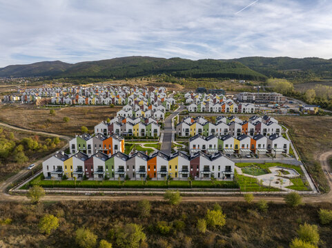 Aerial view of Residential Park Lozen featuring modern colorful townhouses with green lawns and paved streets in Sofia, Sofia City Province, Bulgaria.