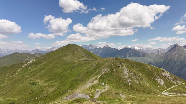 ⁠Cinematic aerial drone shot approaching rolling green alpine meadows and mountain ridges in Obernberg am Brenner, Austria.⁠